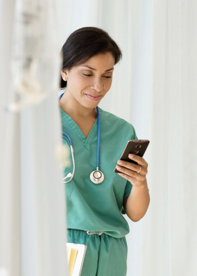 Woman in scrubs looks at mobile phone